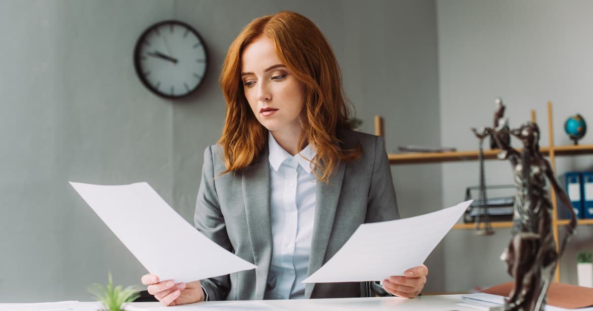 A female lawyer in a professional setting reviewing documents related to personal injury lawyer fees and percentages in Florida.